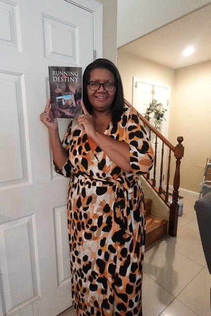 Woman holding Running Destiny book.