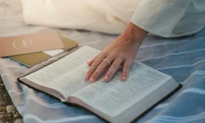 Hand resting on open book.