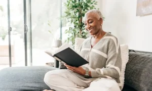 Smiling woman reading book indoors.